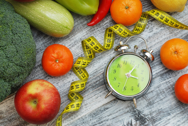 Time to lose weight. fruits, vegetables and alarm clock. dieting. Premium Photo